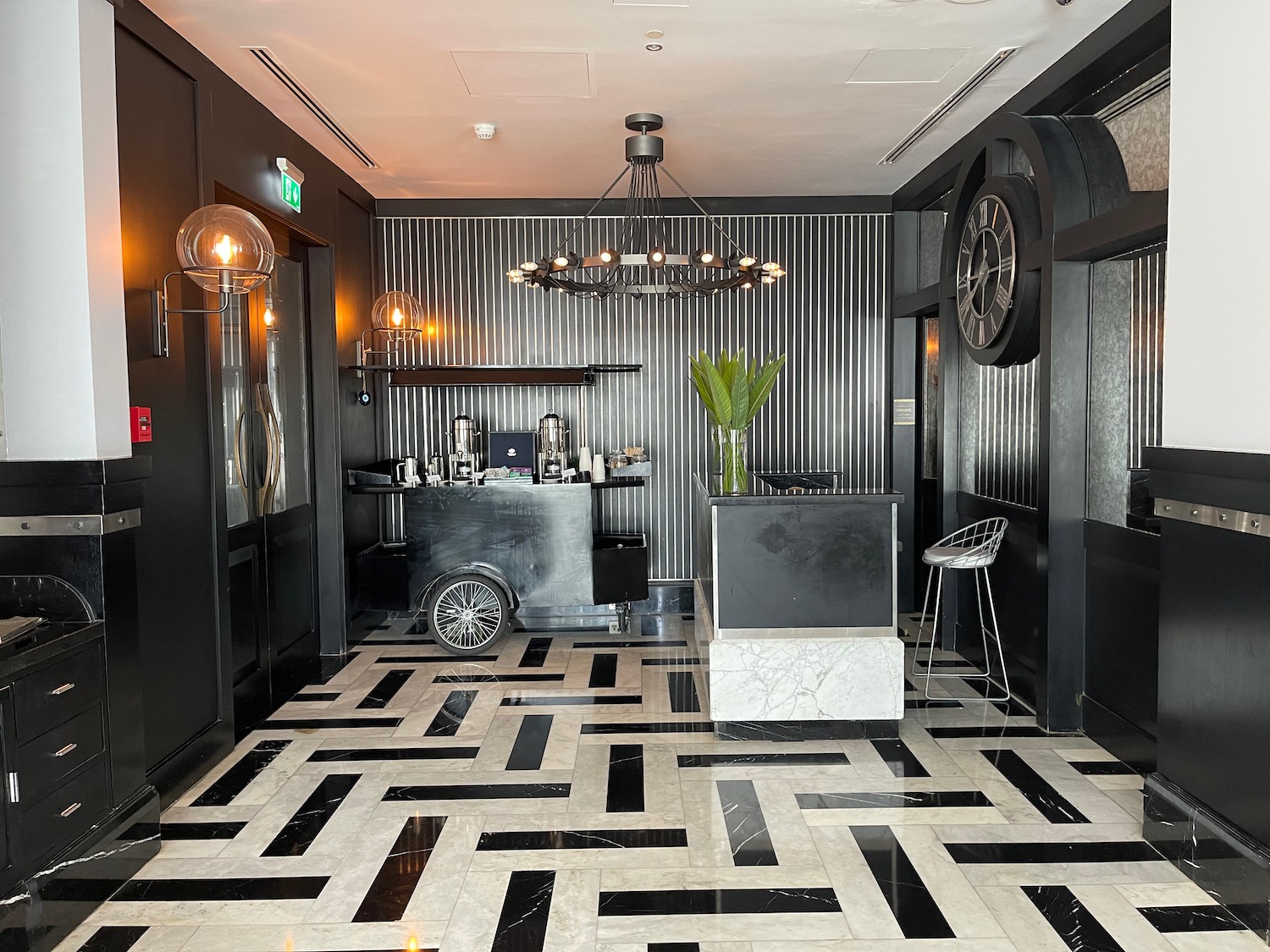 a black and white room with a bar counter and a chandelier