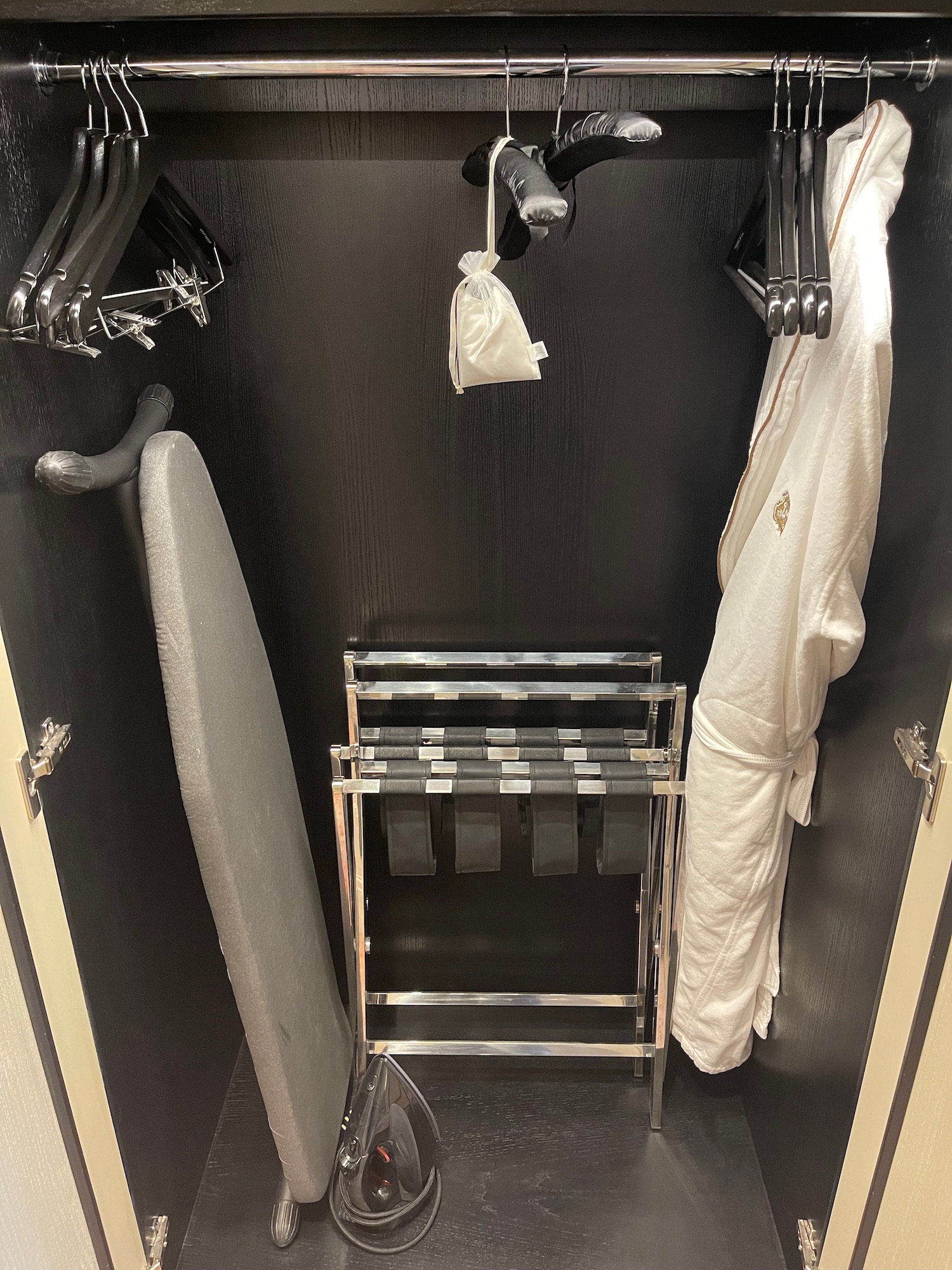 a black closet with white robe and swingers