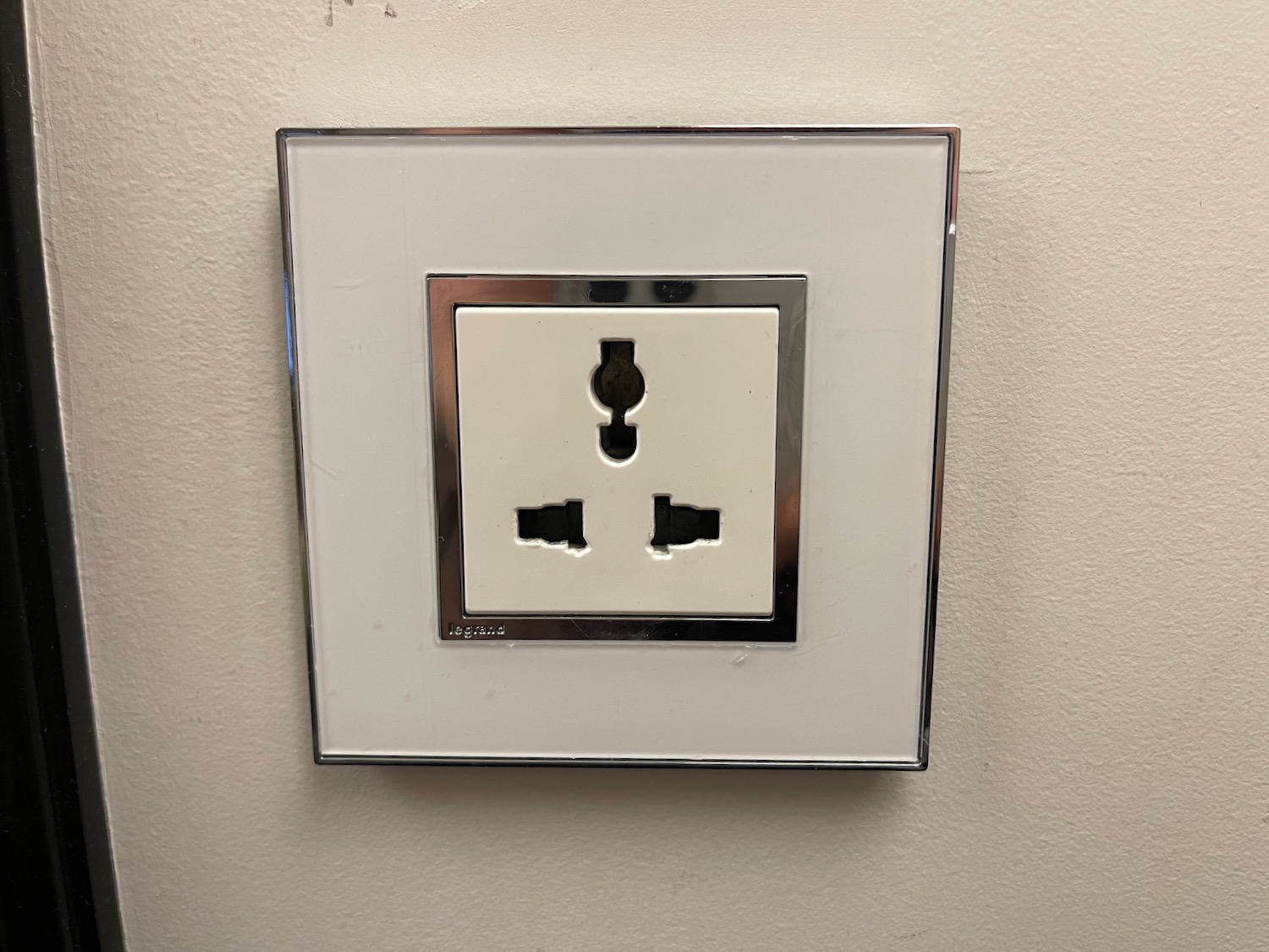 a white wall outlet with silver trim
