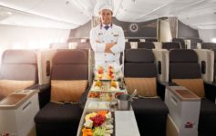 a man in a chef uniform standing in an airplane