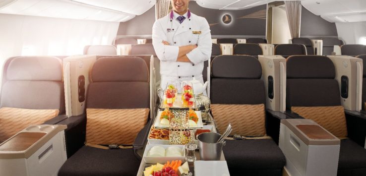 a man in a chef uniform standing in an airplane