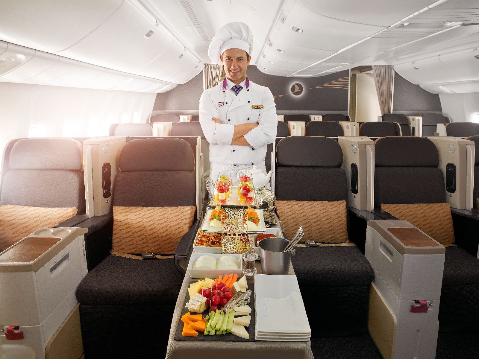 a man in a chef uniform standing in an airplane