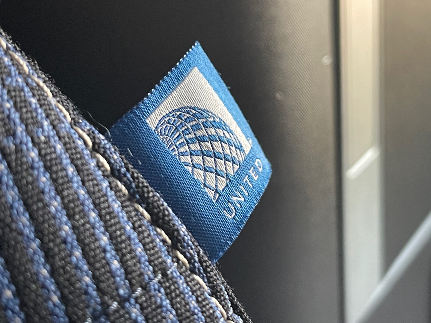 a blue and white label on a black and grey fabric