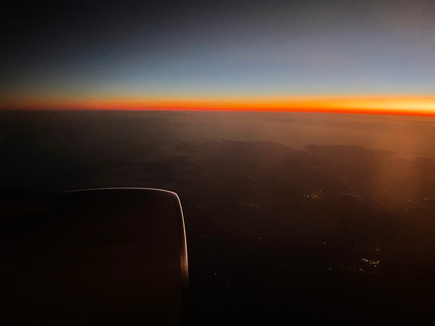 an airplane wing with a sunset in the background