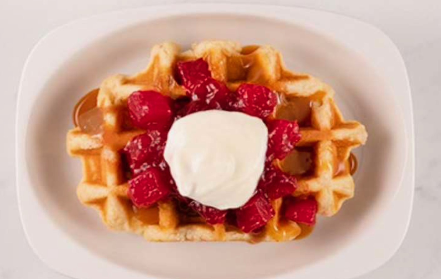 a waffle with fruit and whipped cream on top