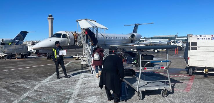 people standing next to a plane