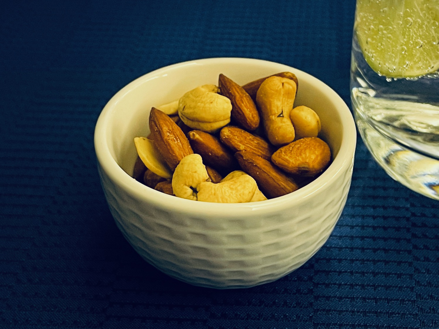 a bowl of nuts and a glass of water