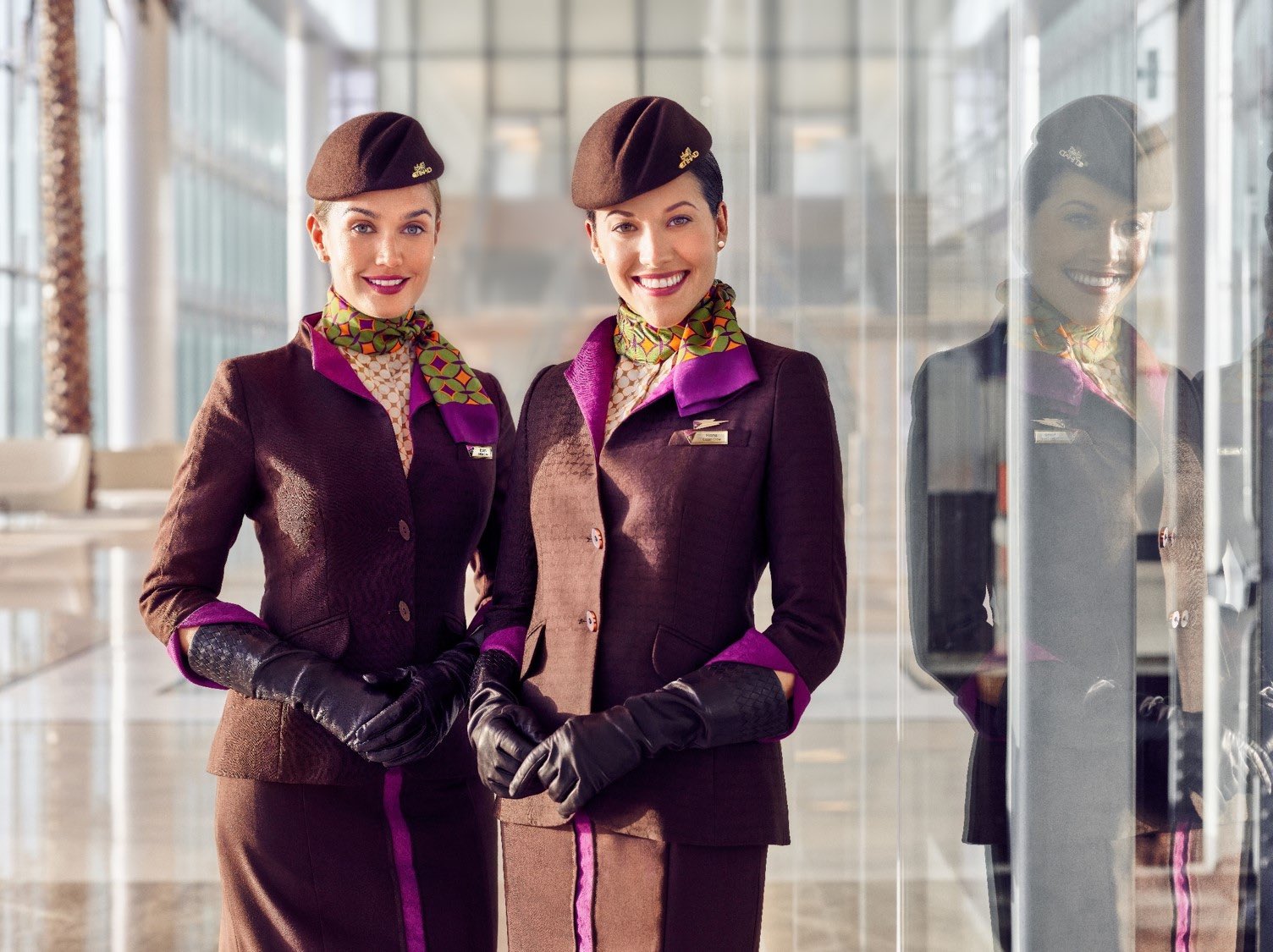 two women wearing uniforms and smiling