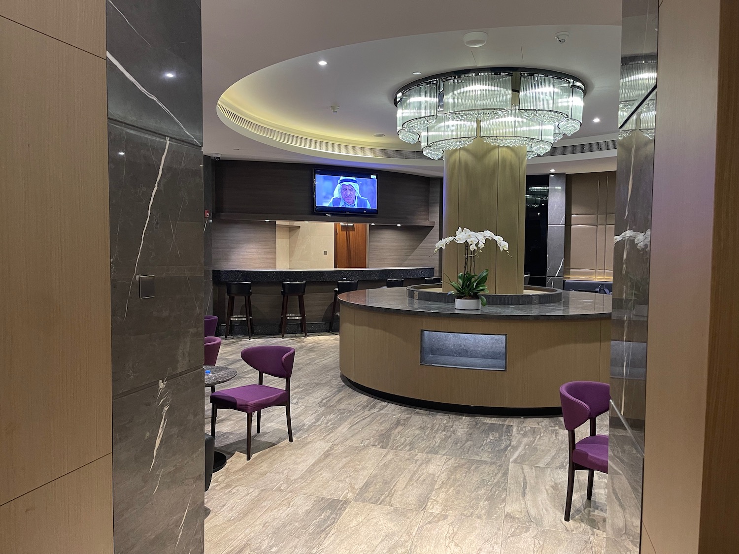 a room with a round counter and purple chairs