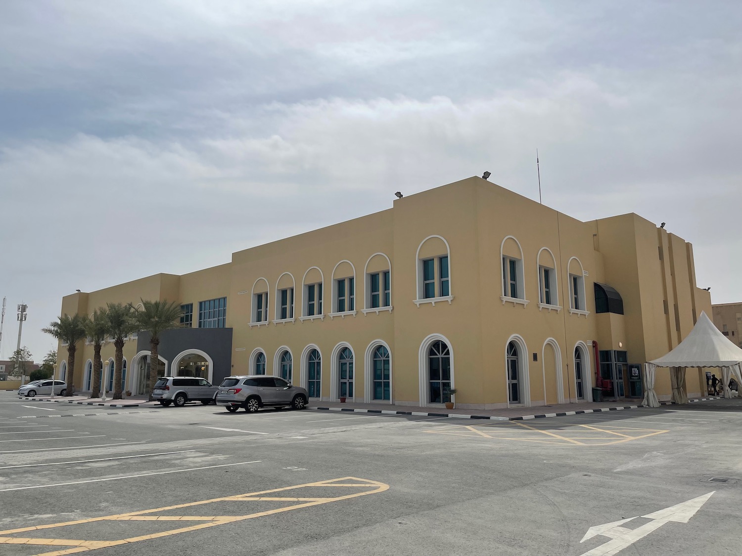 a building with palm trees and a parking lot