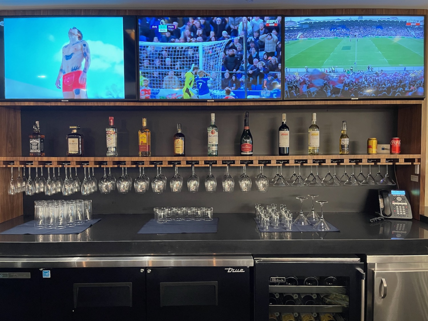 a bar with several tvs and glasses
