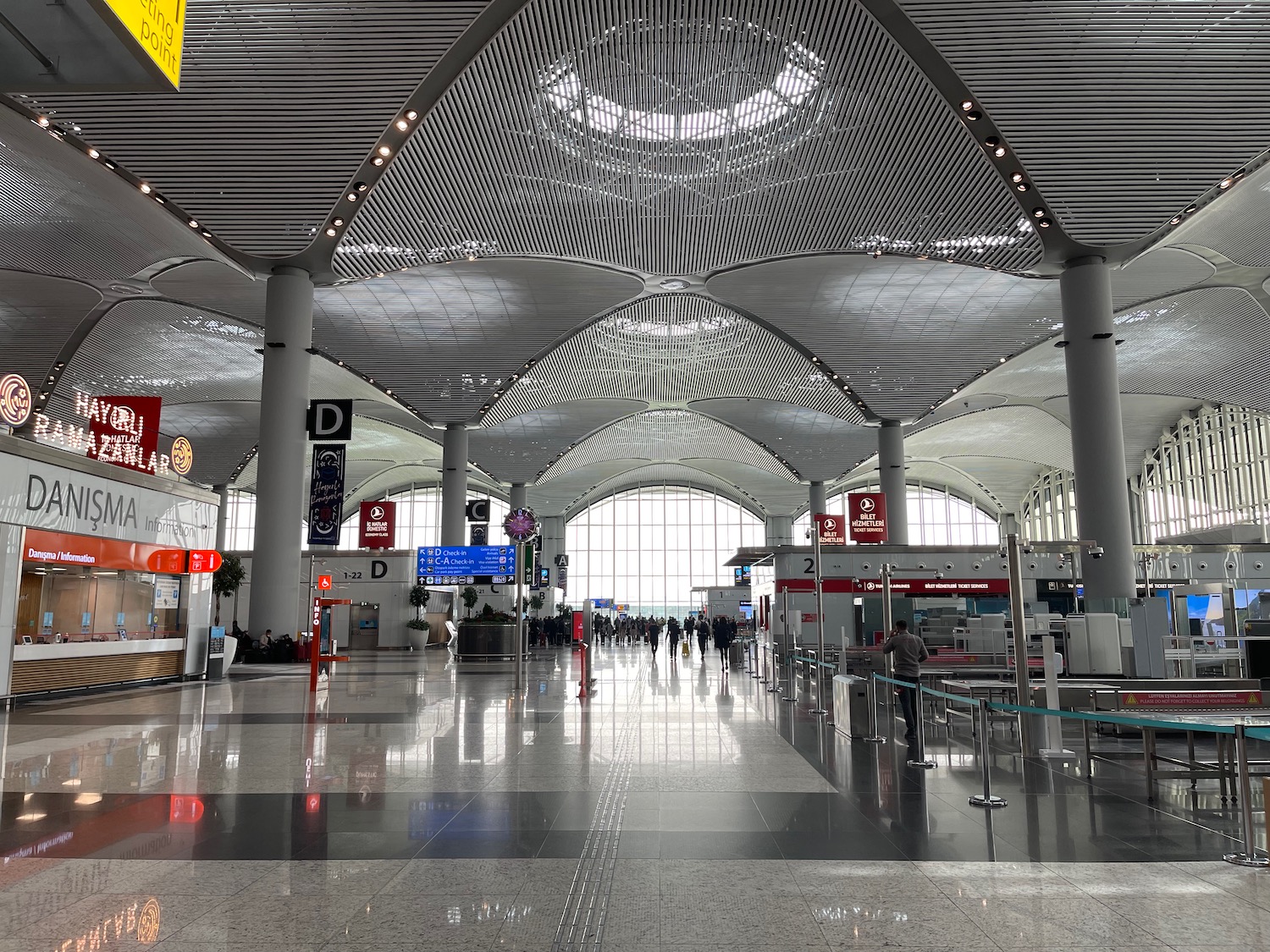 a large airport terminal with people walking around