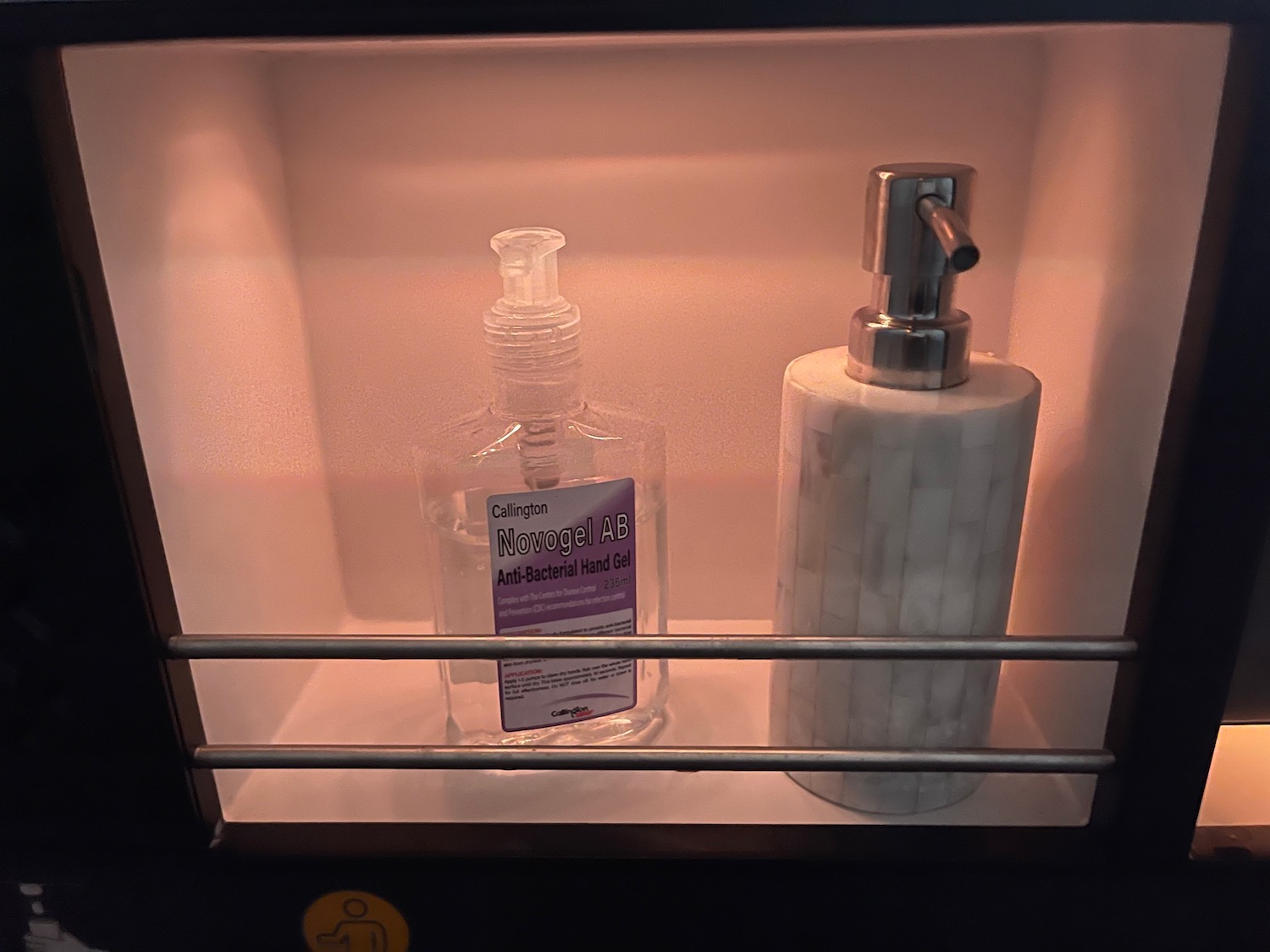 a bottle and soap dispenser in a shelf