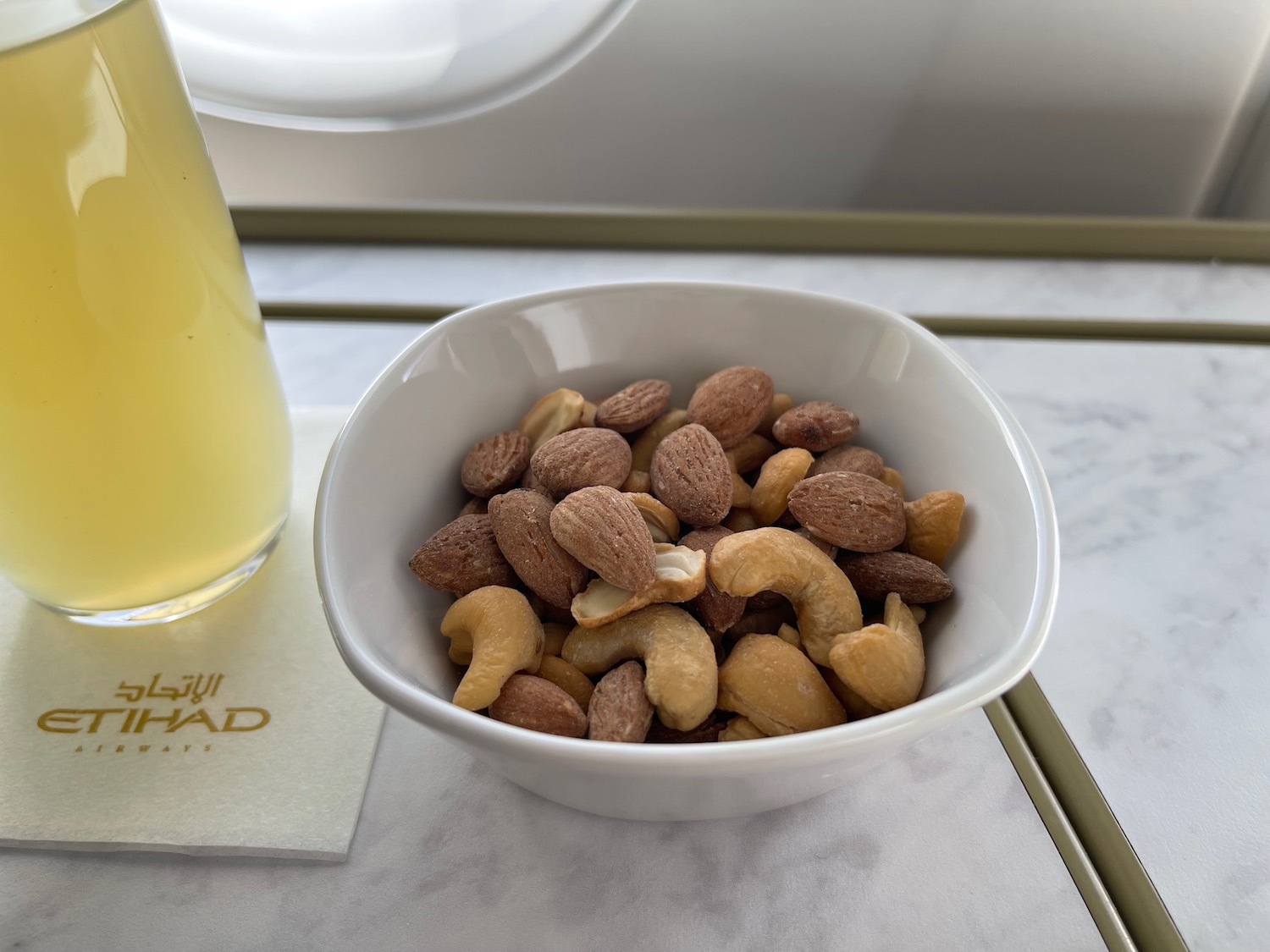 a bowl of nuts and a glass of juice