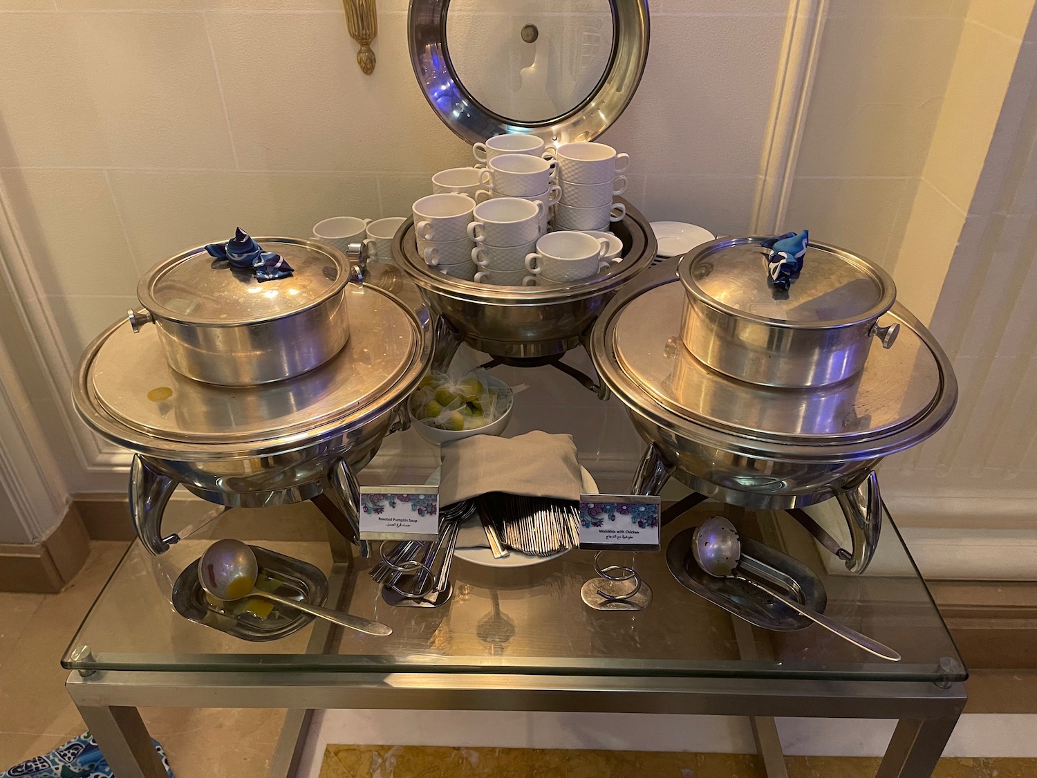 a group of silver pots and cups on a glass table