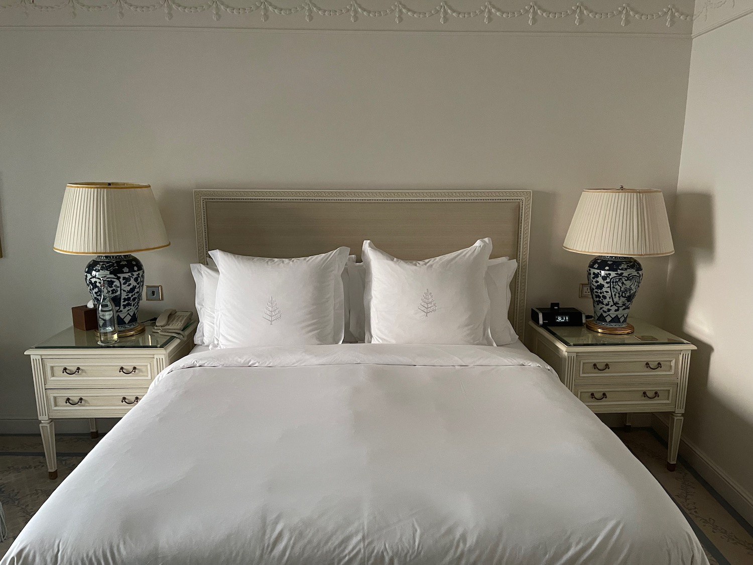 a bed with white sheets and lamps