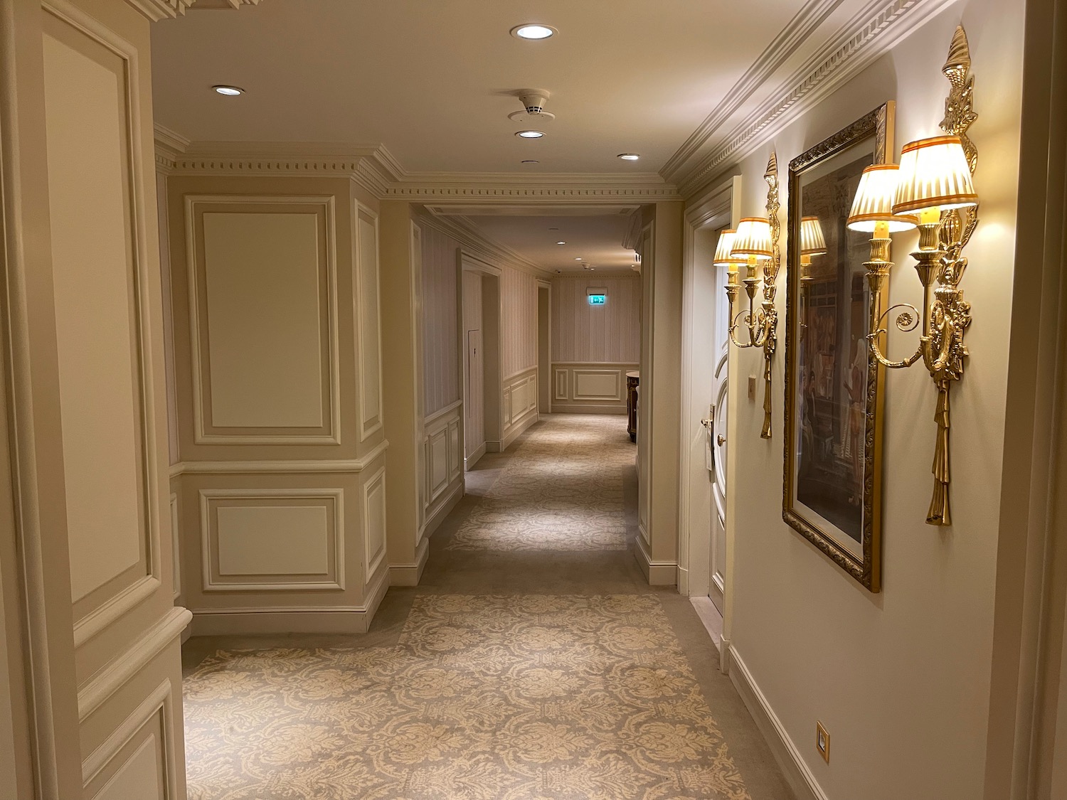 a hallway with sconces and lamps