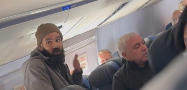 a man with a beard sitting in a plane