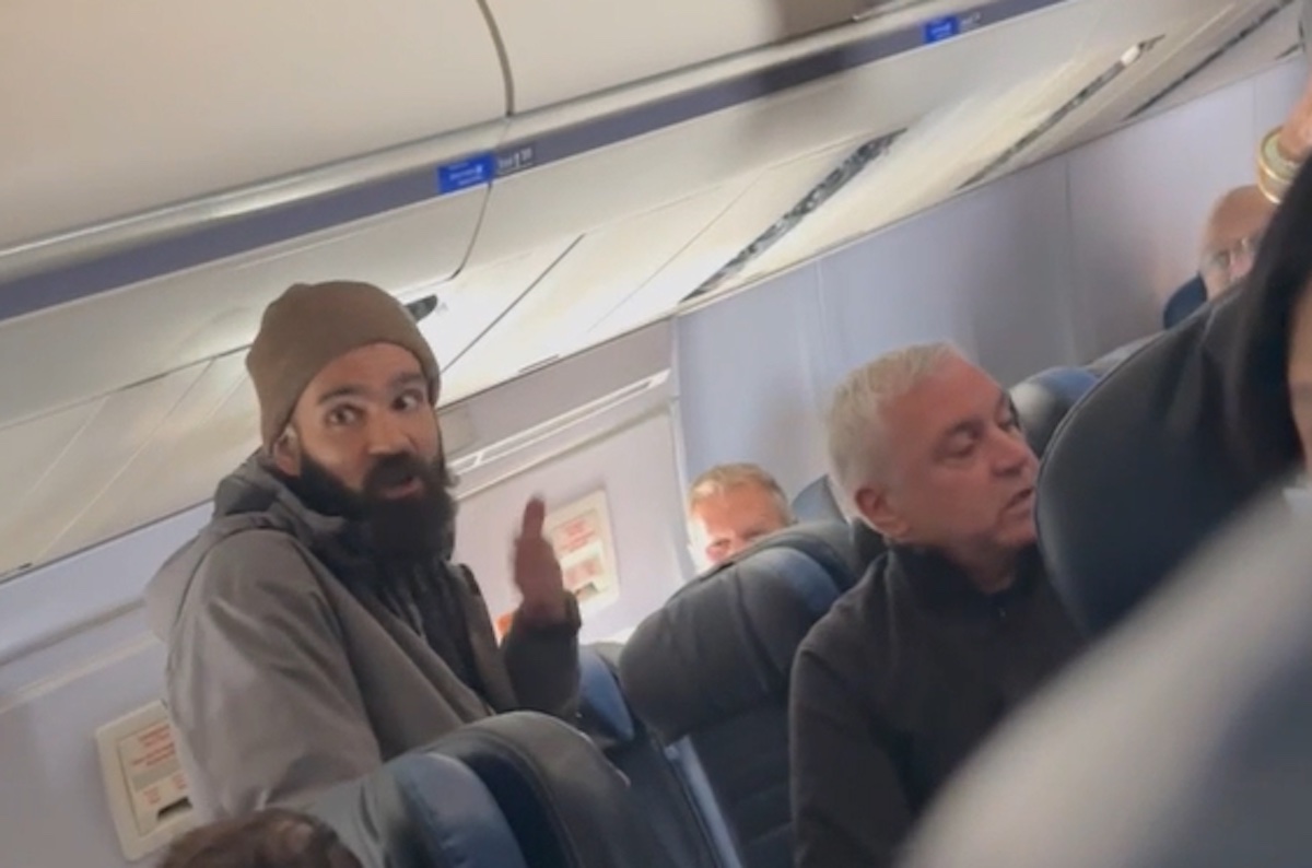 a man with a beard sitting in a plane