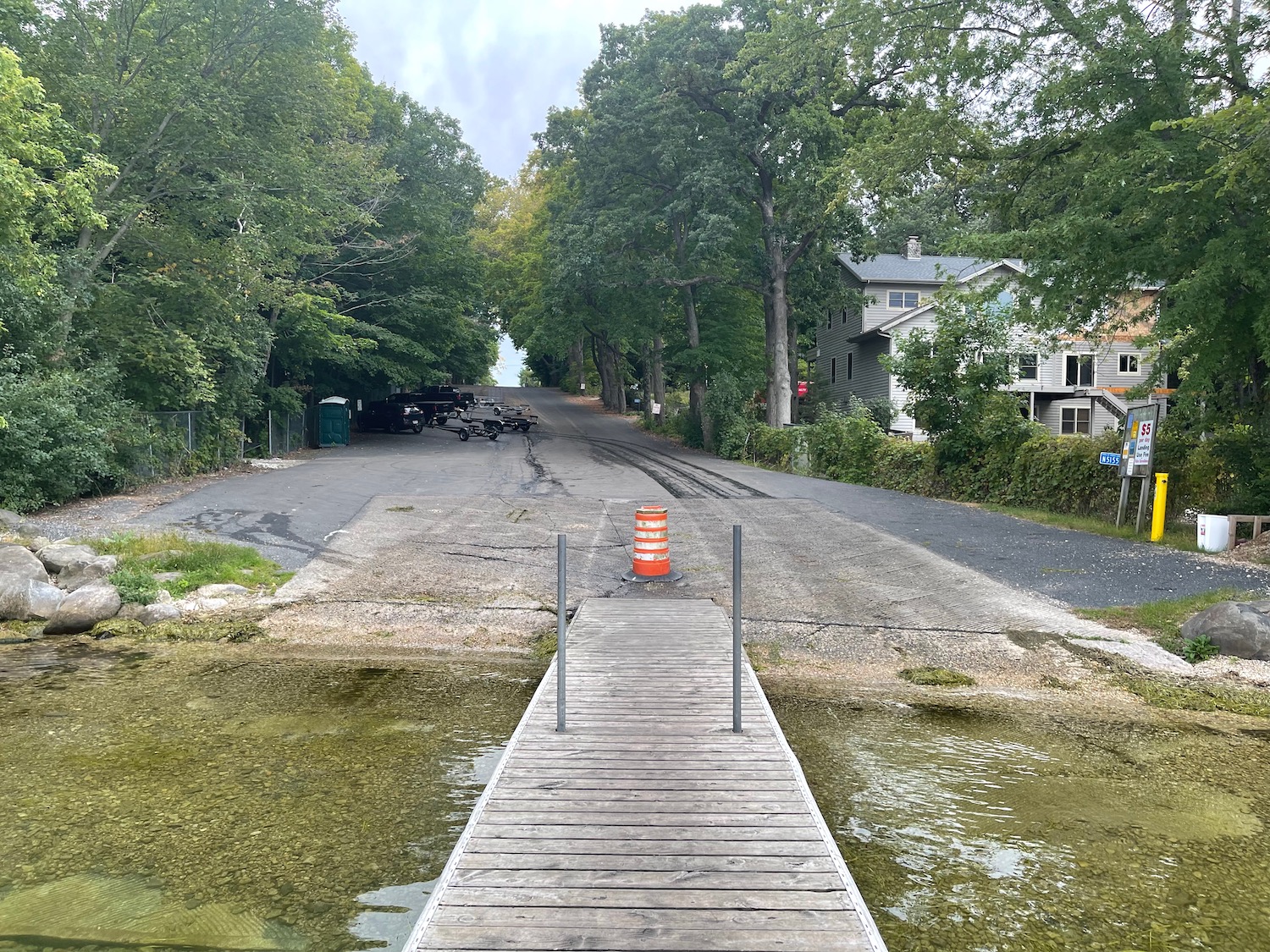 a wooden dock over a road with trees and houses