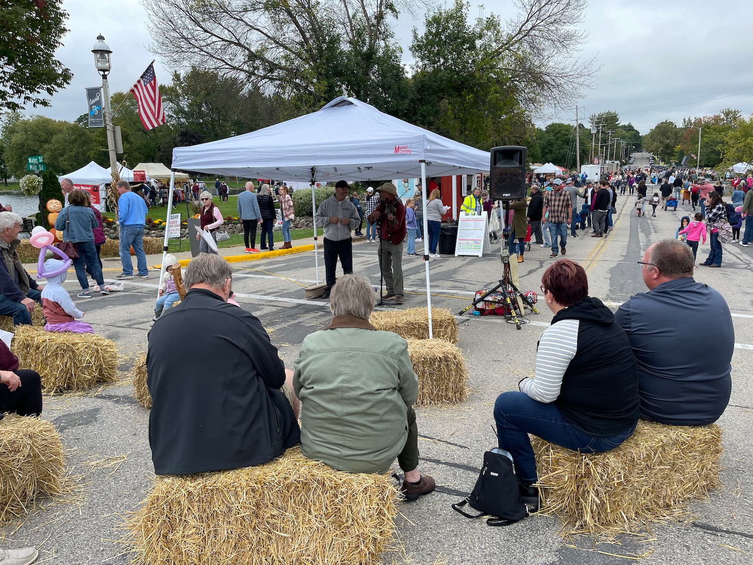 a group of people sitting on hay bales