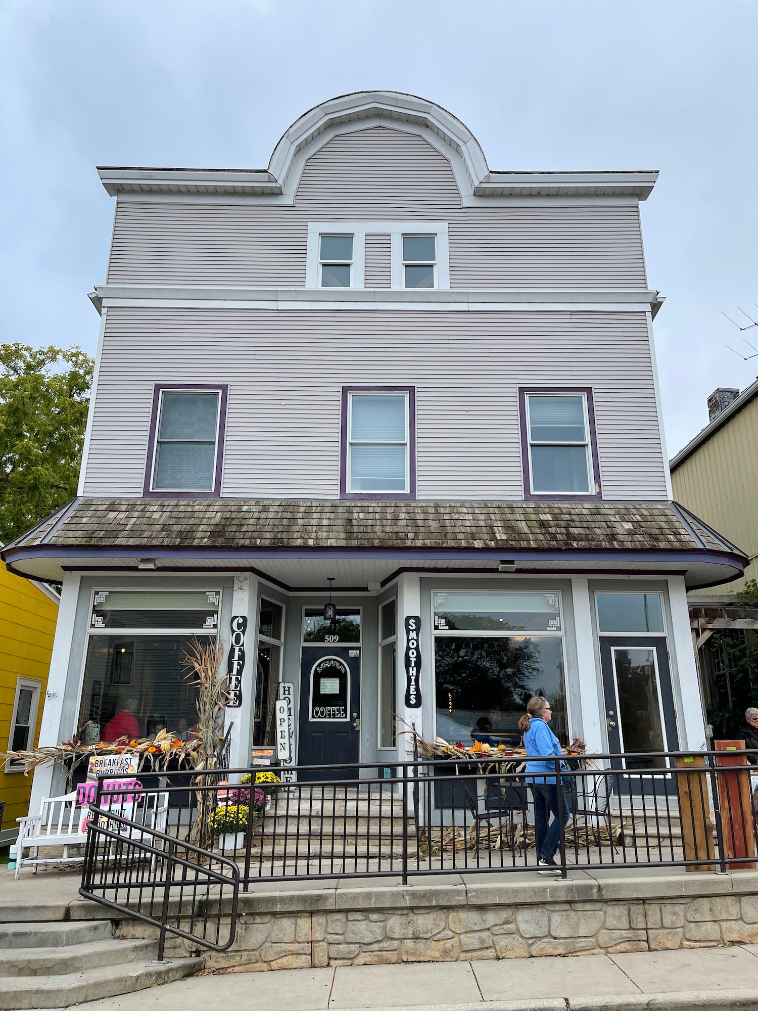 a building with a railing and people walking in front of it