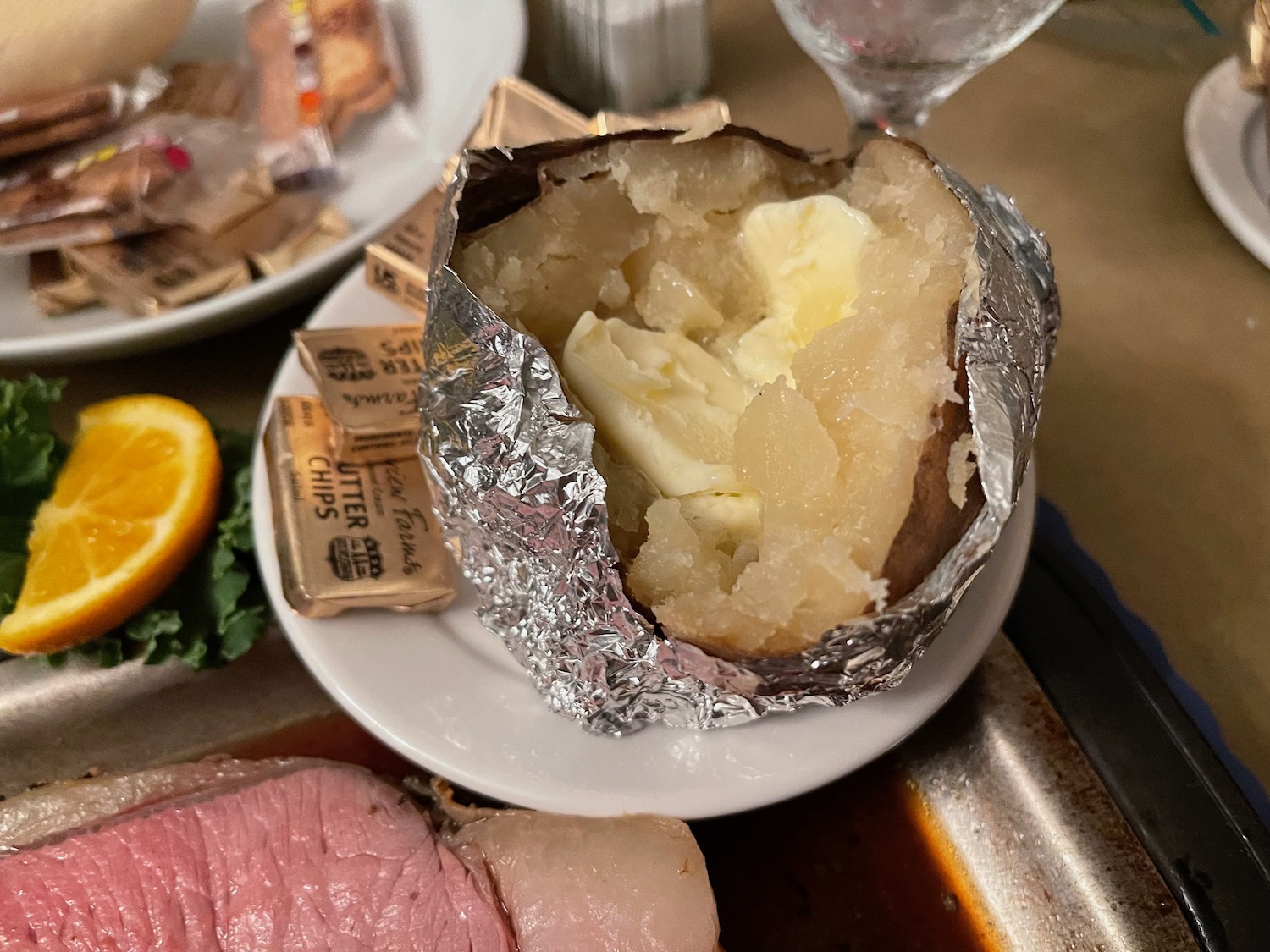 a baked potato with butter on a plate