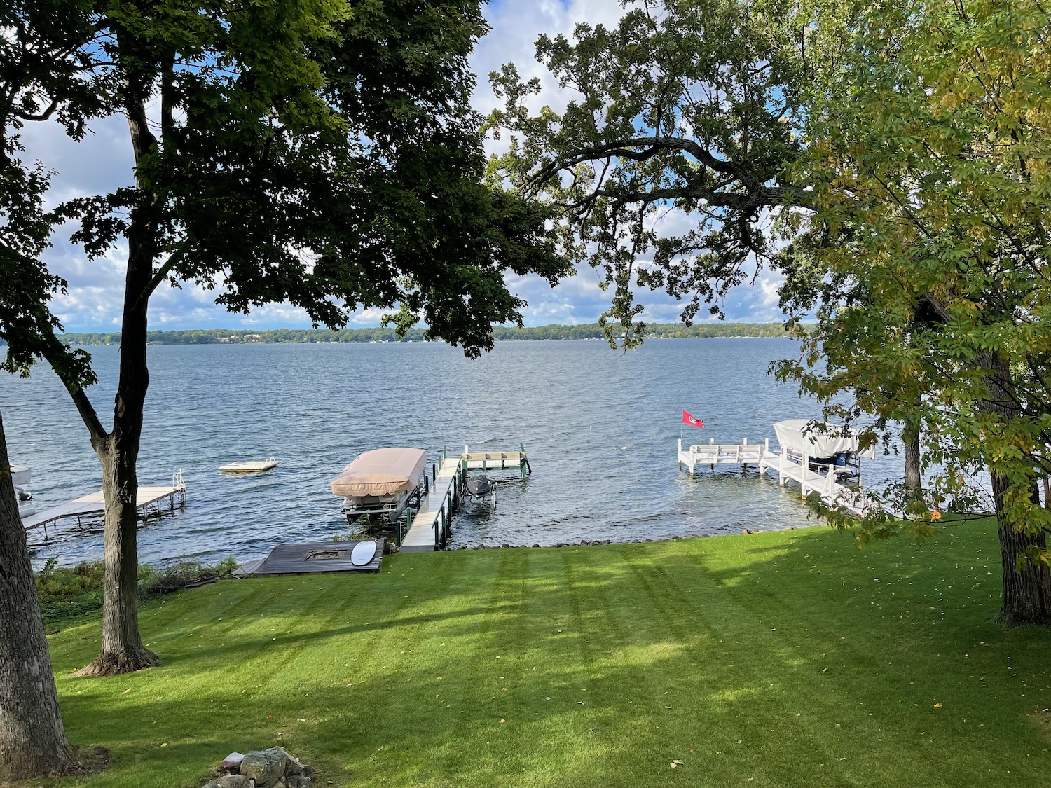 a lawn with a dock and boats on the water