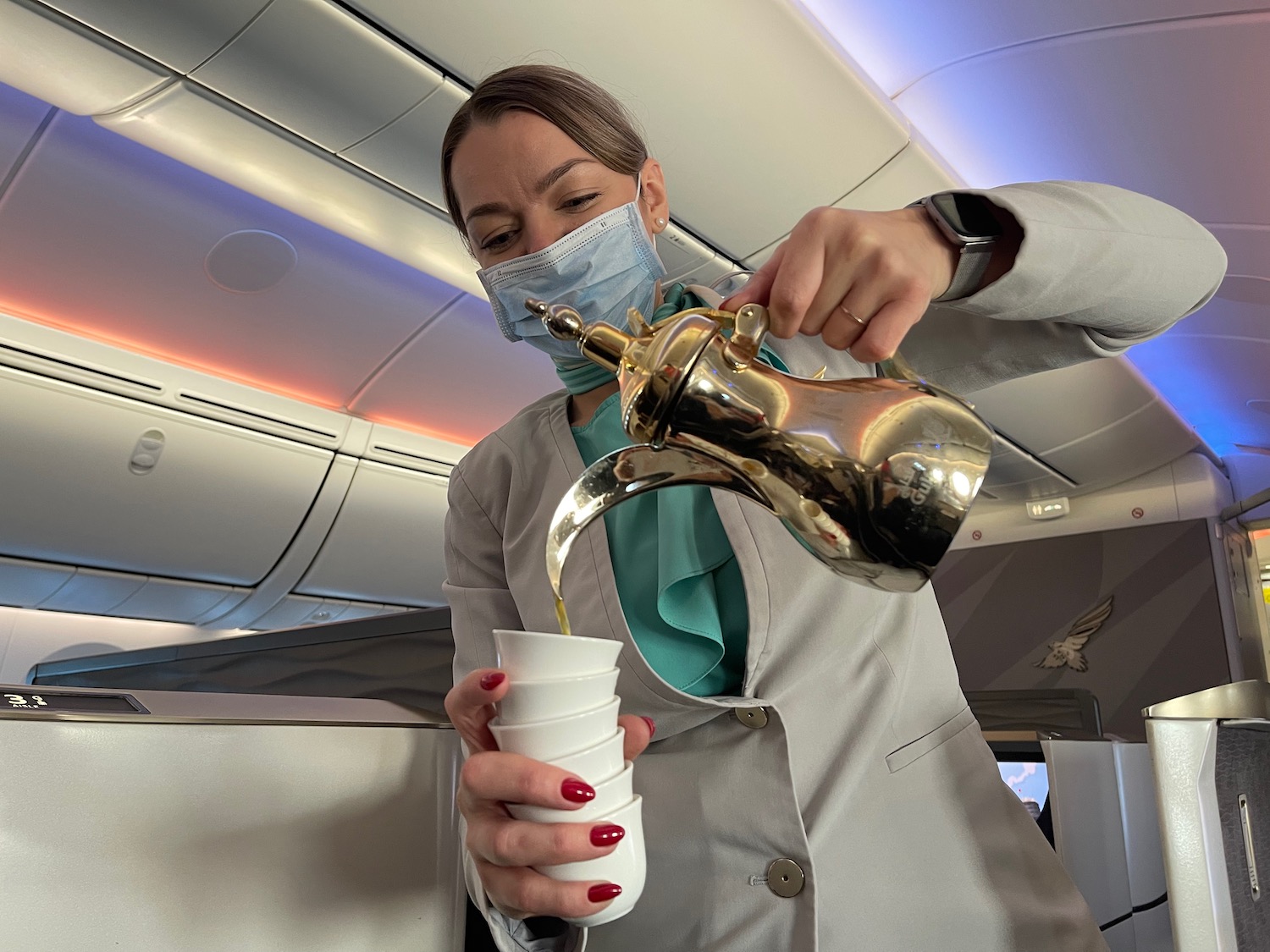 a woman wearing a mask pouring liquid into a cup