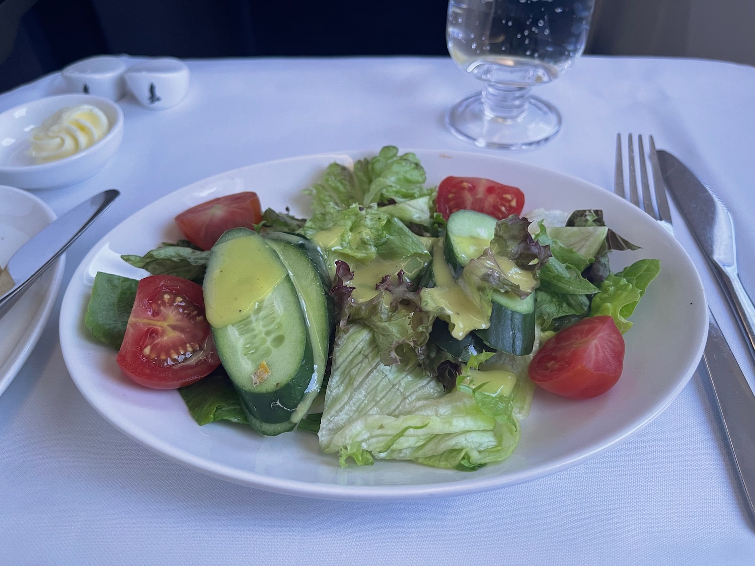 a plate of salad with cucumbers and tomatoes