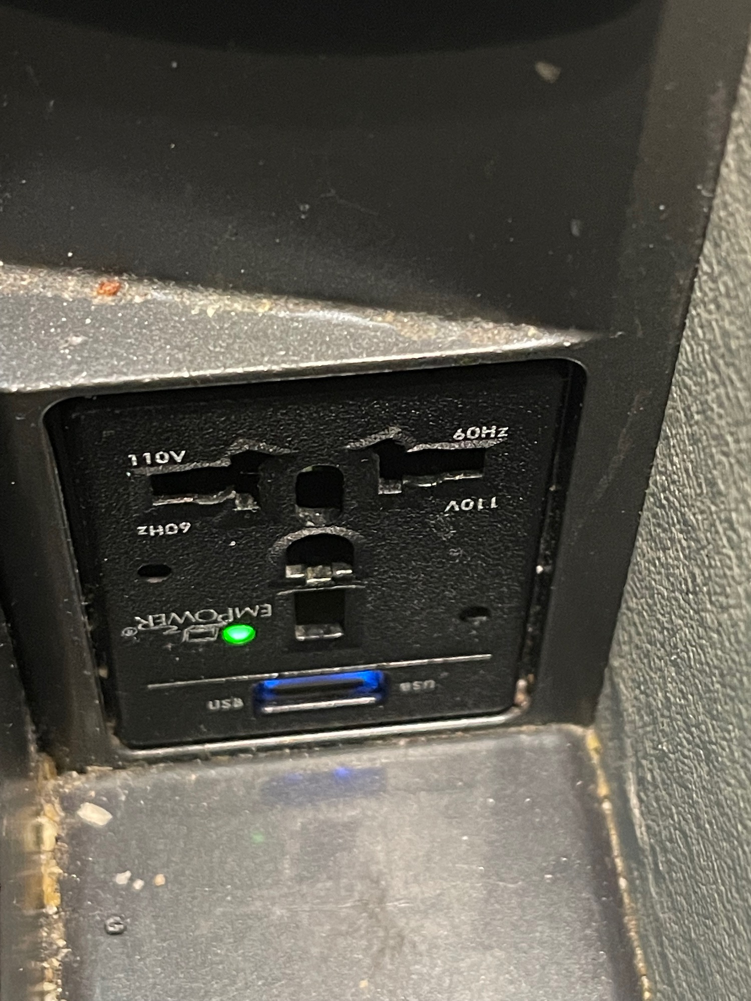 a black electrical outlet with a green light