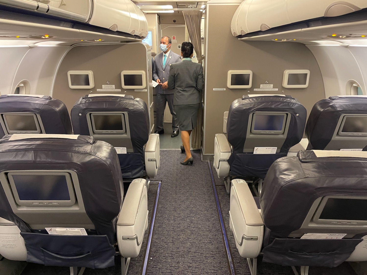 a man and woman in a mask standing in an airplane