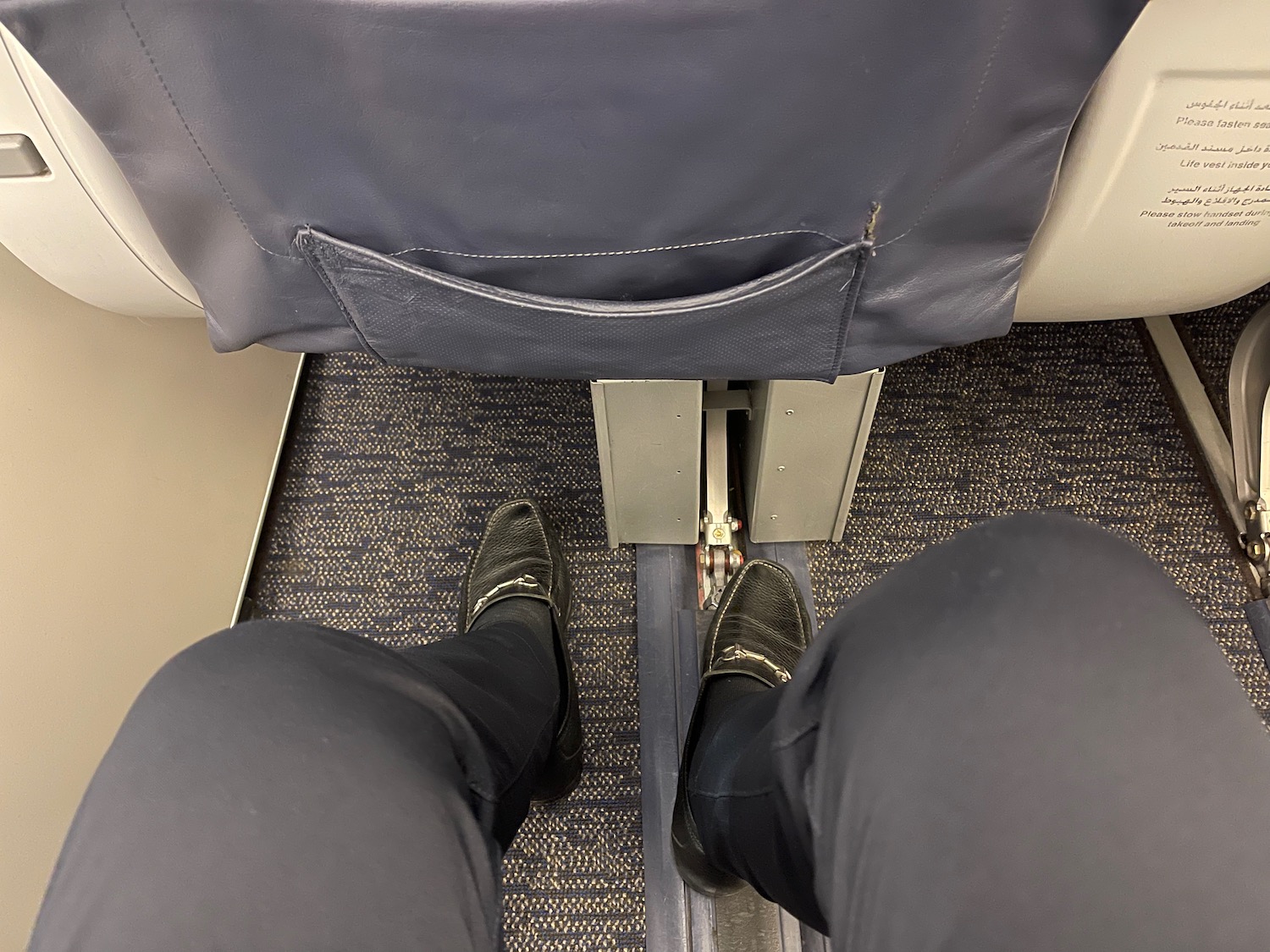 a person's legs and feet on an airplane