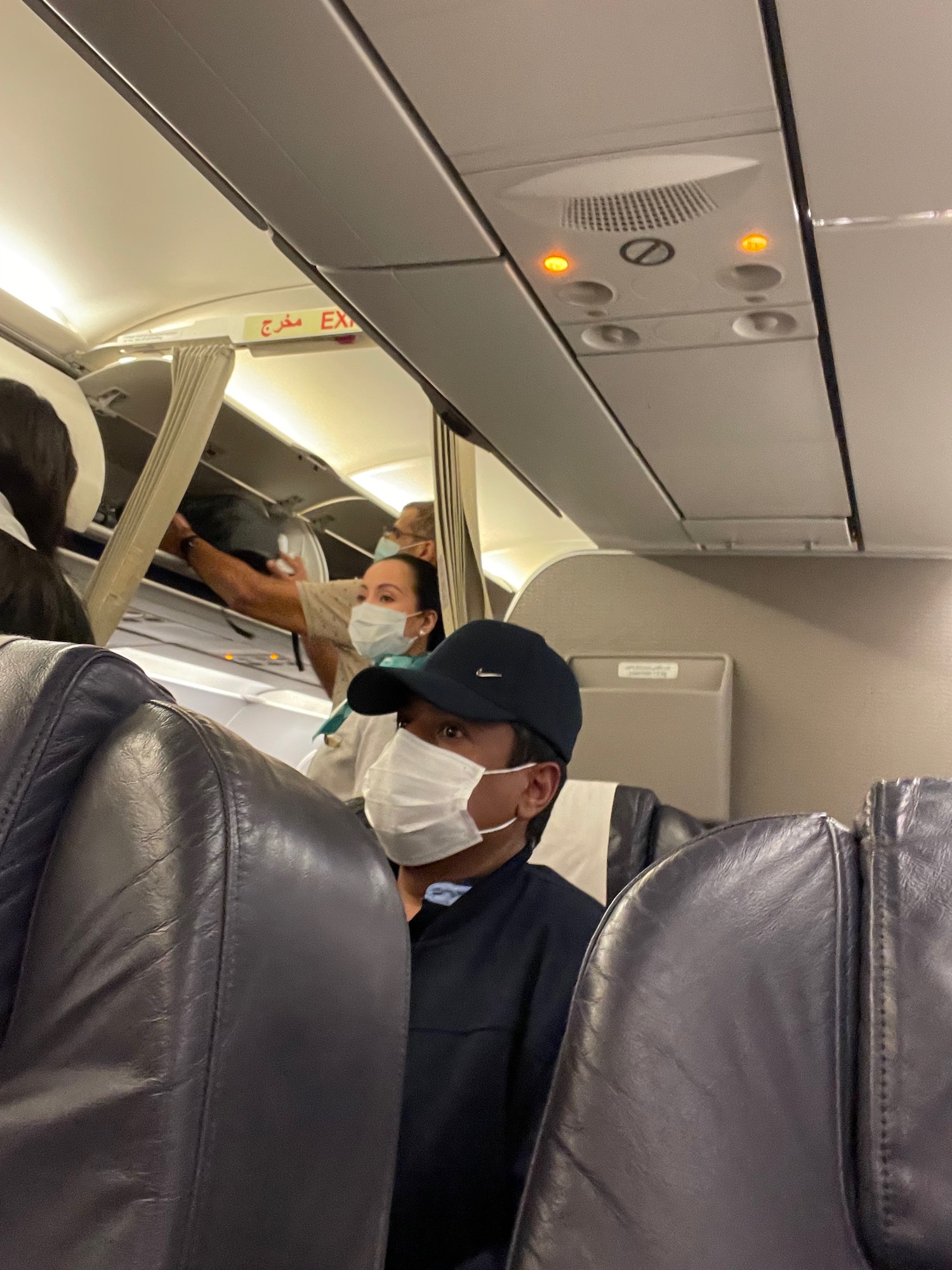 a group of people wearing face masks on an airplane