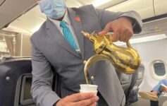 a man wearing a mask pouring liquid into a cup