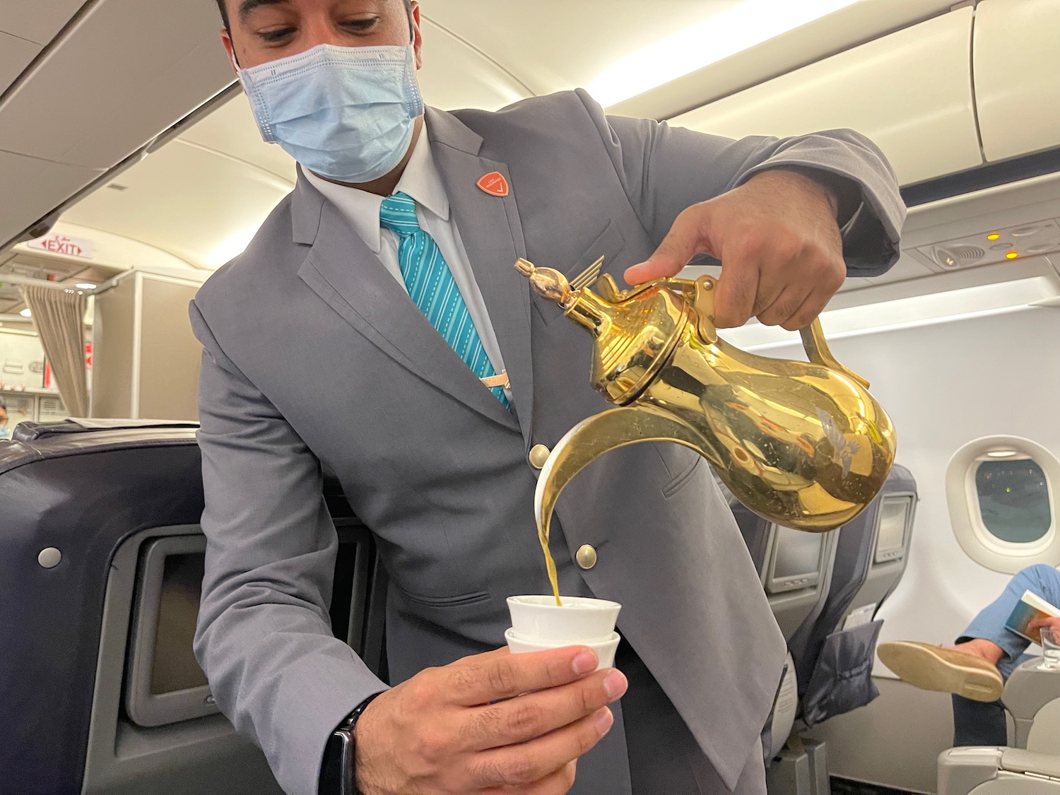 a man wearing a mask pouring liquid into a cup