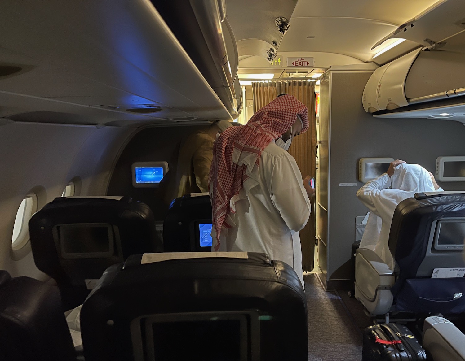 a man in a white robe standing in an airplane