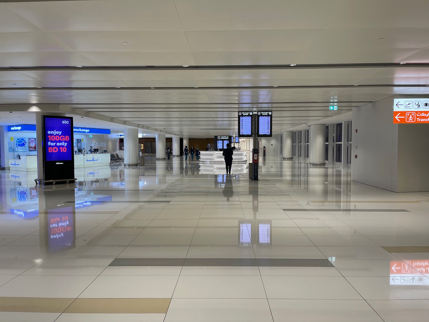 a large white tiled floor with people walking in it