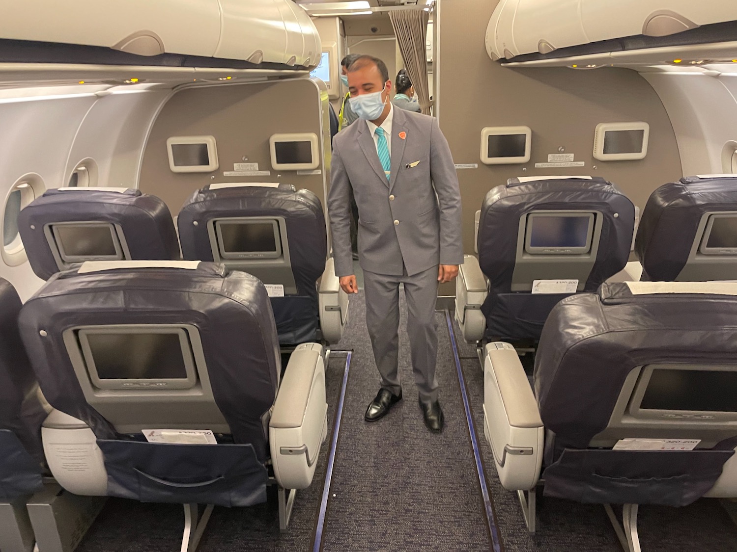 a man wearing a mask and standing in an airplane