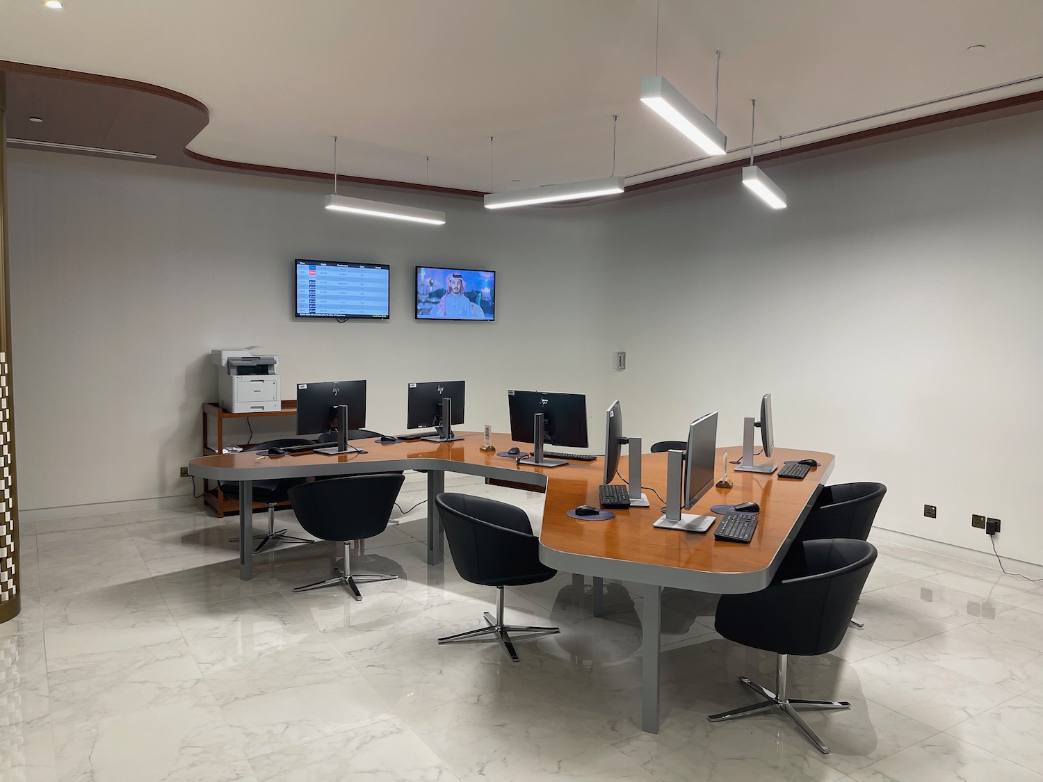 a room with a desk and chairs and computers