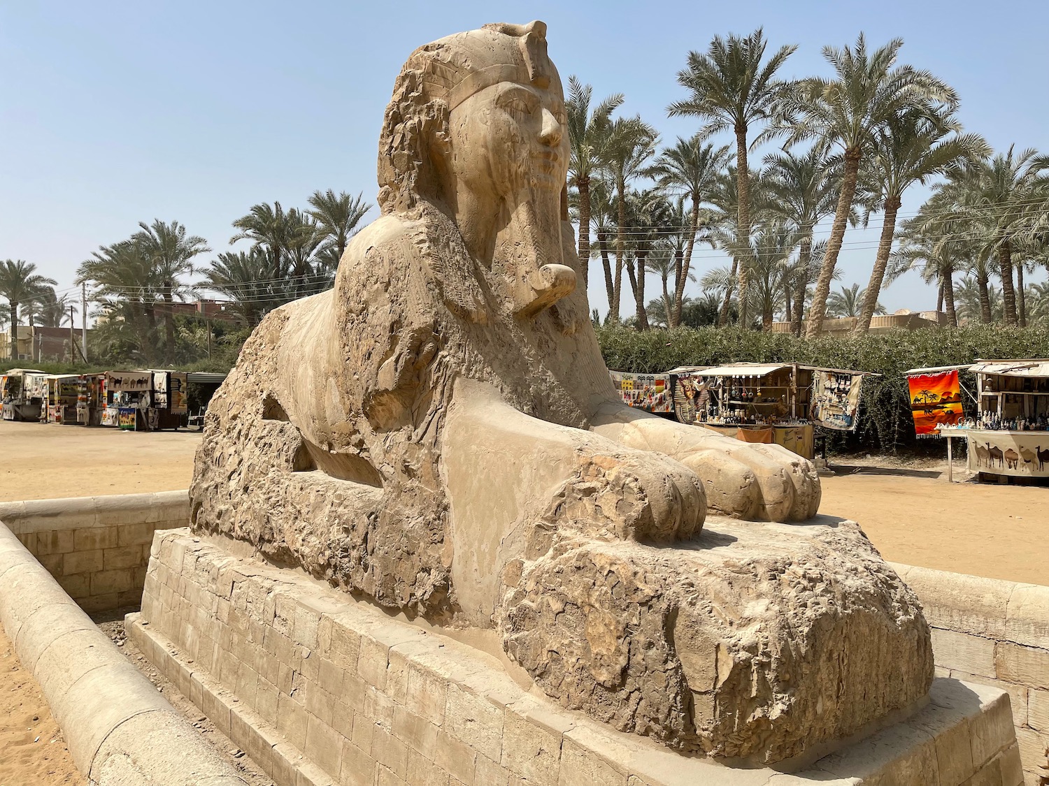 a stone statue of a sphinx with Memphis in the background