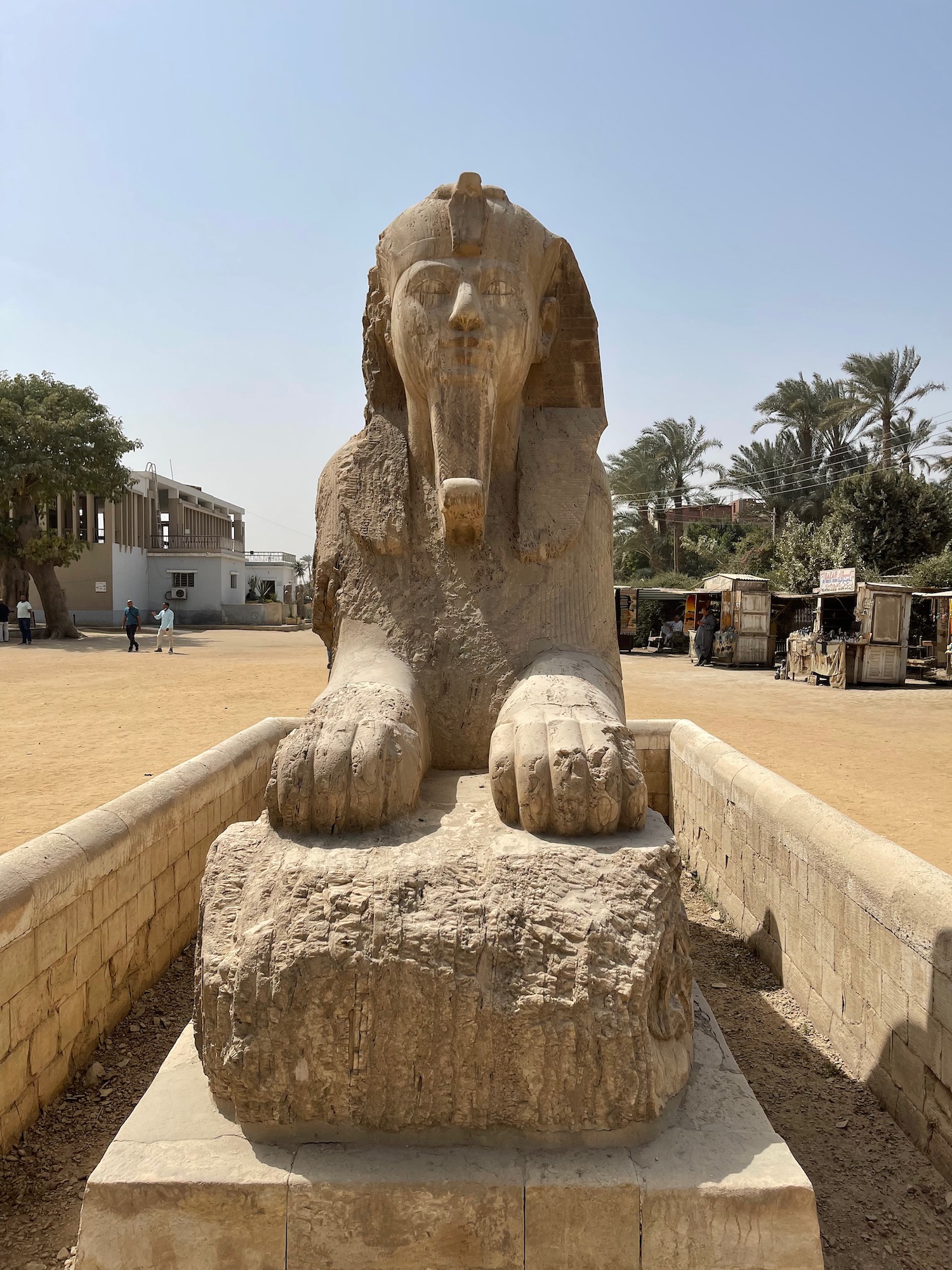 a stone statue of a sphinx with Memphis in the background