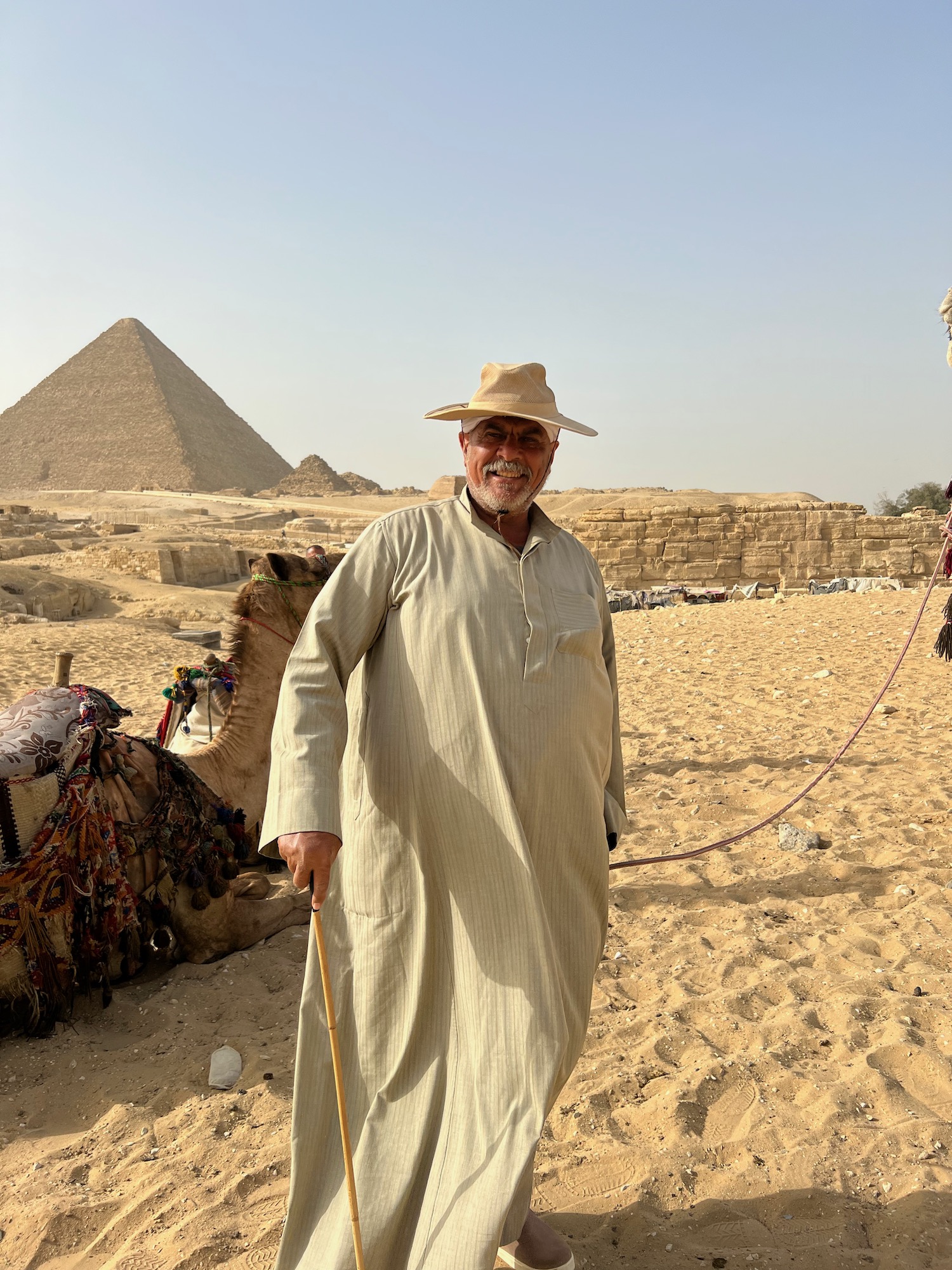 a man standing next to a camel