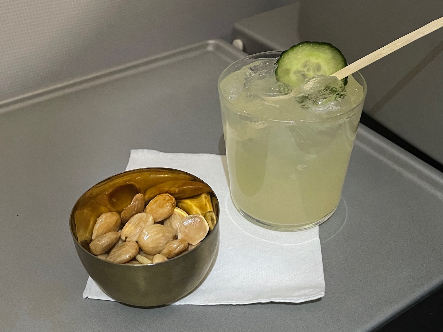 a bowl of nuts and a drink on a tray