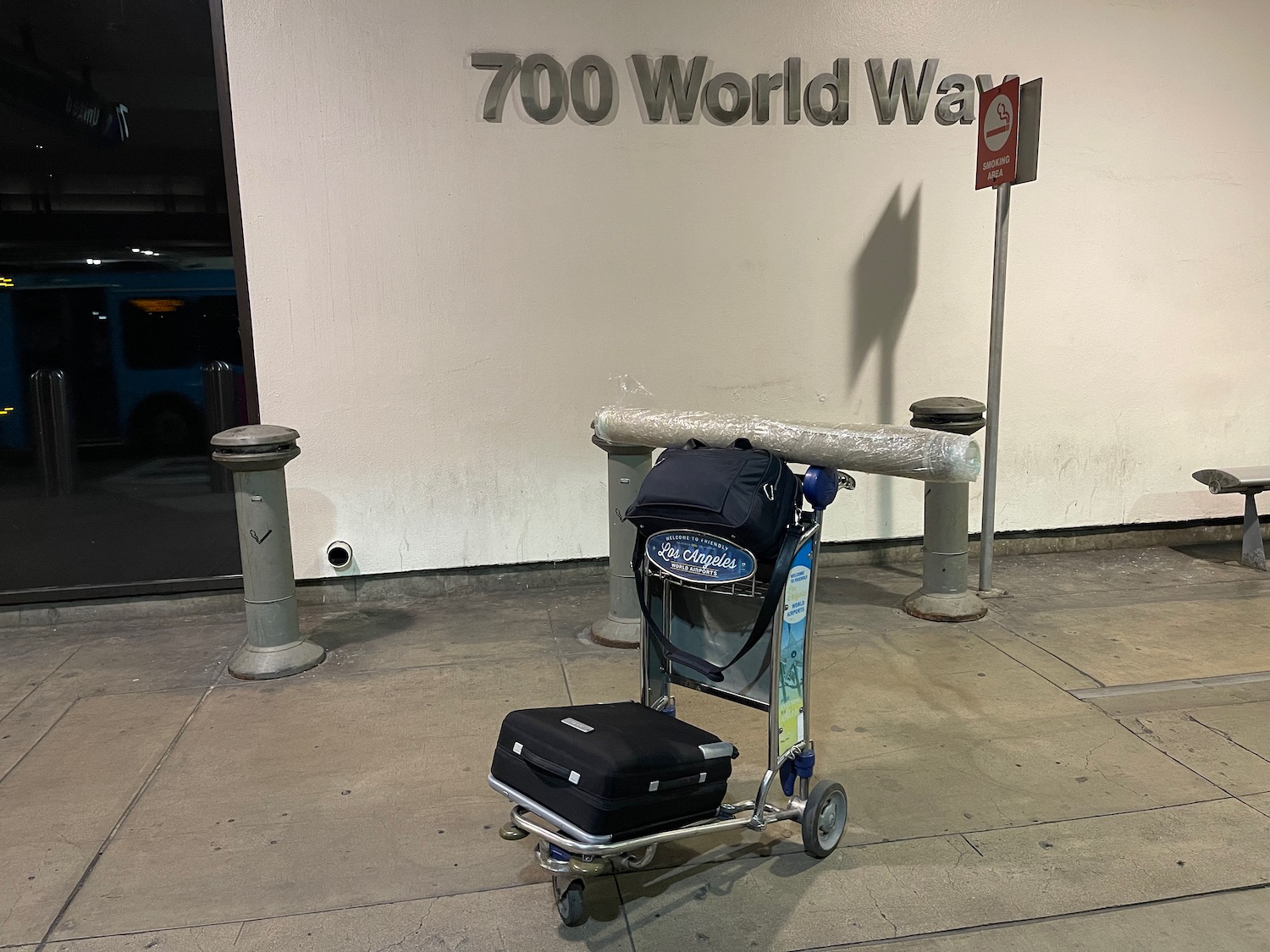 luggage cart with luggage on it outside of a building