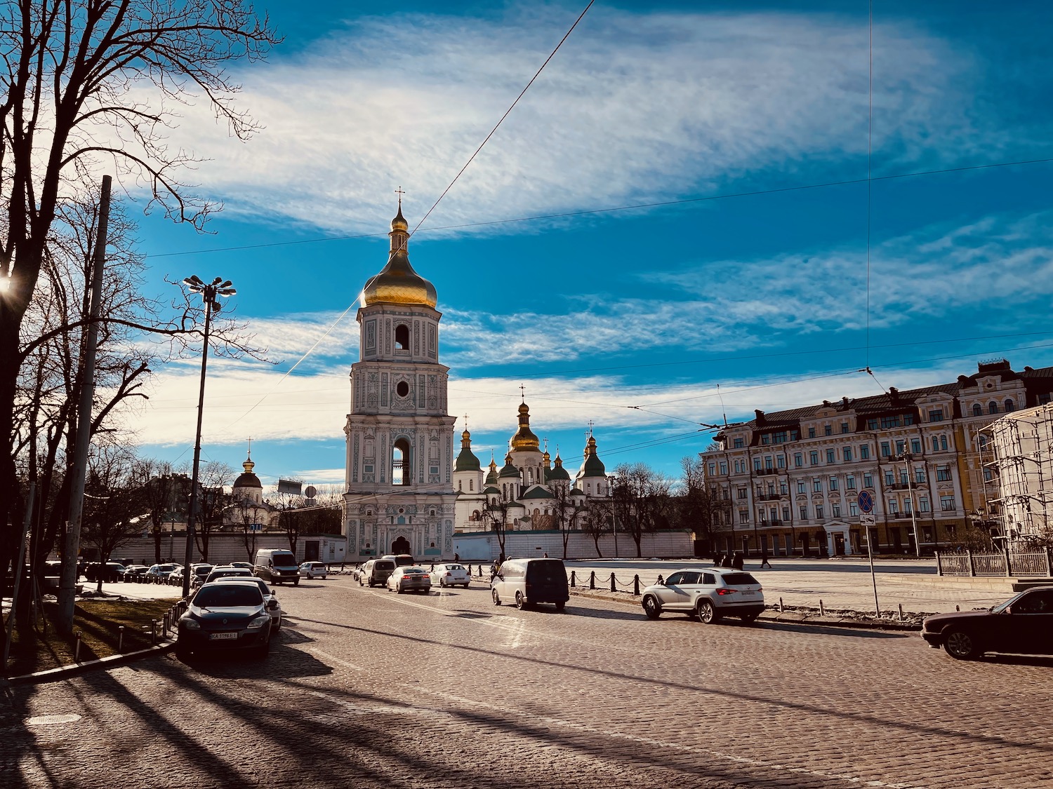 a street with cars and a building with a tower