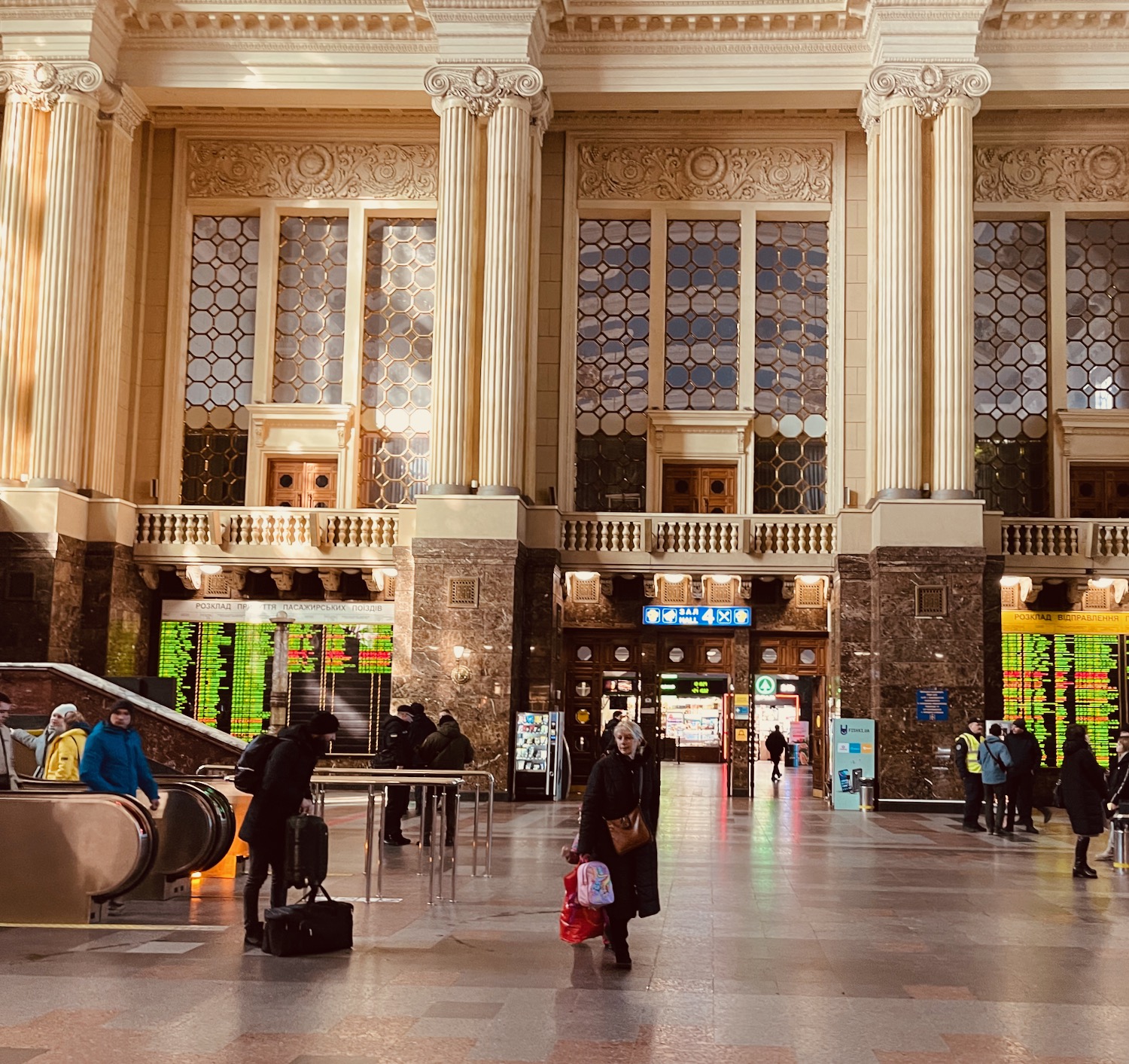 a large building with columns and people walking around