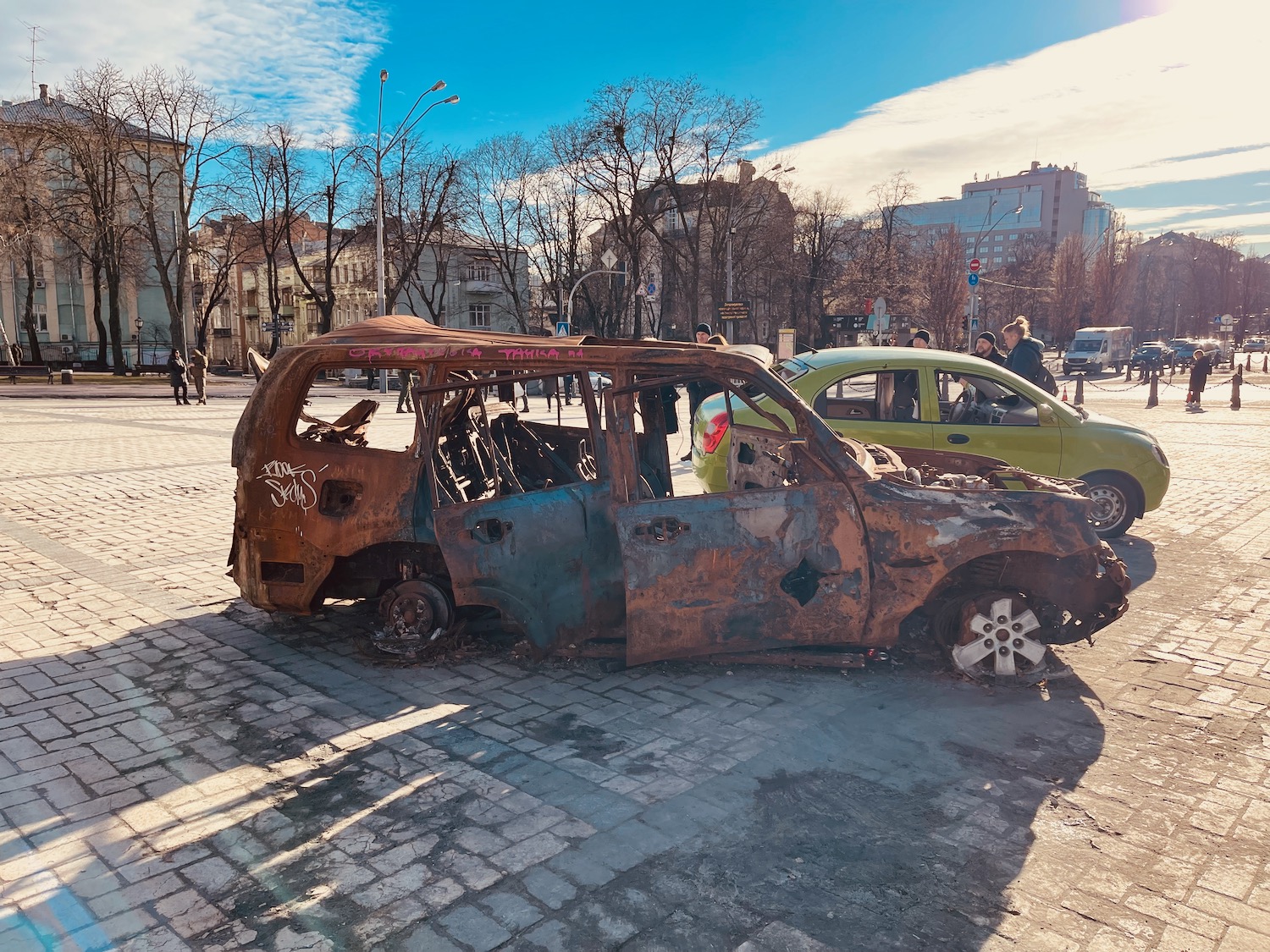 a rusted car on a brick road