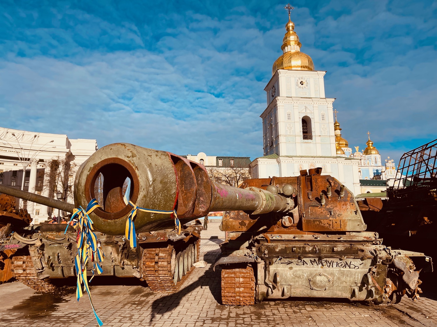 a tank with a large barrel in front of a building