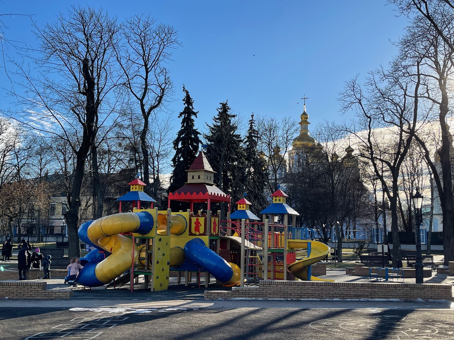 a playground with a slide and a building in the background